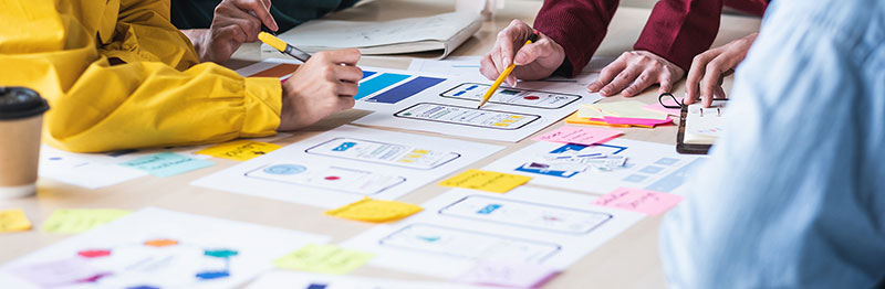 An image of people working on paper prototyping concepts for a digital product